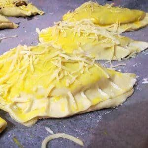 Badigeonnez avec un jaune d’œuf mélangé à une goutte de lait. Parsemez d'un peu de fromage râpé.