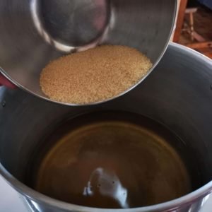 Versez le vin dans une bassine, ajoutez le sucre et mélangez afin de bien le dissoudre.